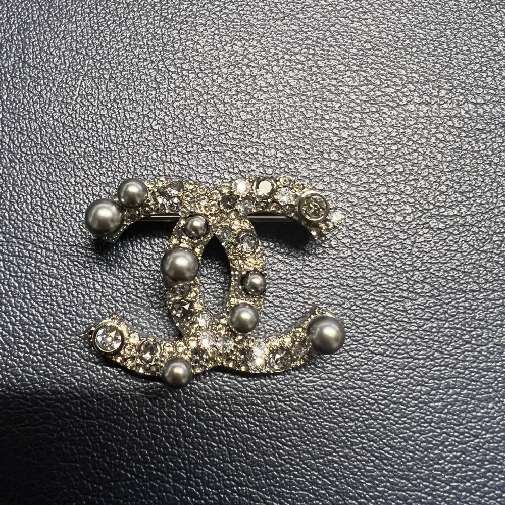 CHANEL Silver Gray Brooch with Iconic Logo Design